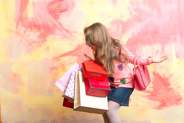 Menina criança com pacote de presente em fundo colorido