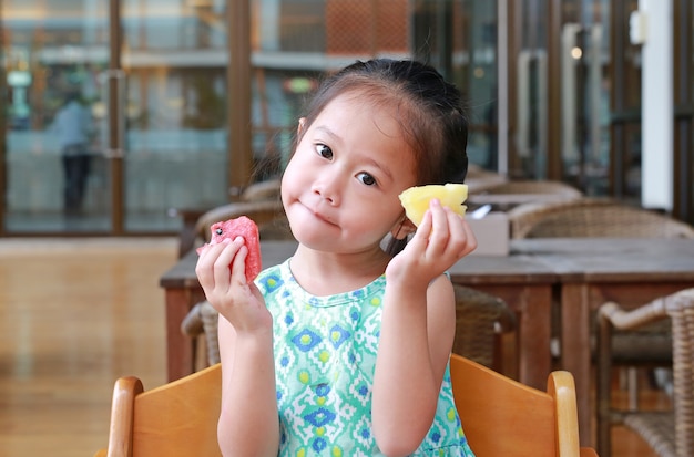 Menina criança comendo frutas fatia