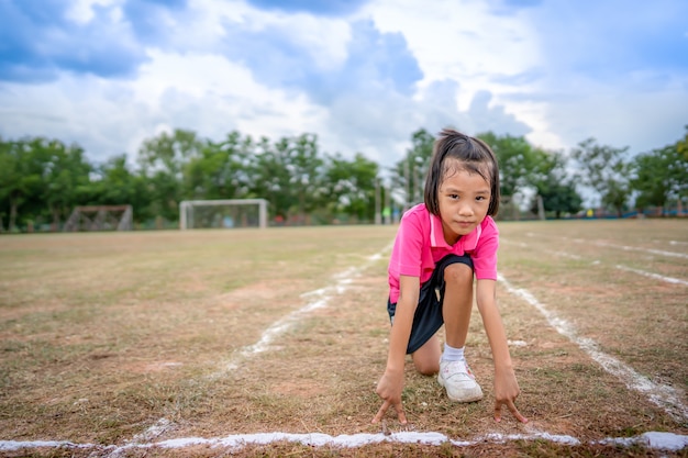 Menina criança correndo corrida na temporada de esporte de verão