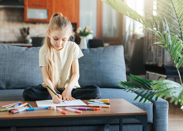 Menina criança desenhando com lápis coloridos