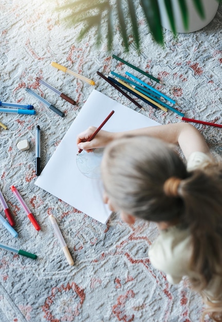 Menina criança desenhando com lápis coloridos