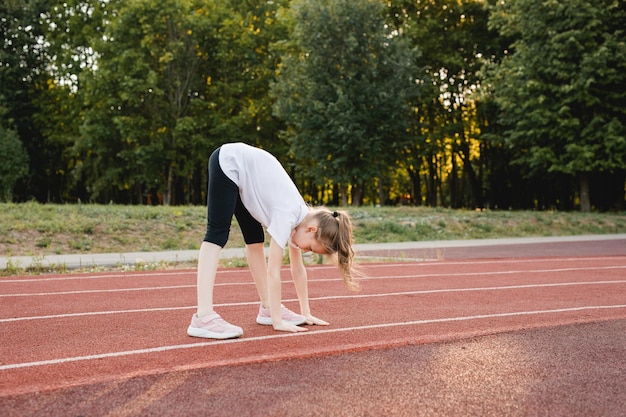 Menina criança esticando antes de correr