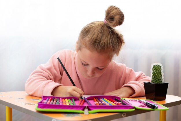 Menina criança fazendo aulas na escola em casa.