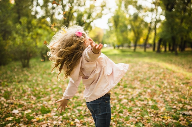 Menina criança feliz se divertindo no parque outono