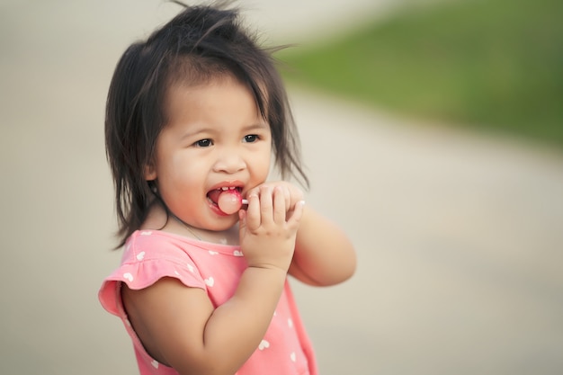 Menina criança gosta de comer doces pirulito