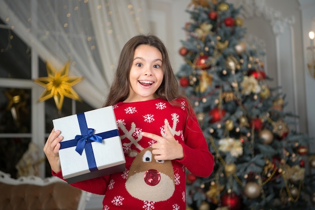 Menina criança gosta de presente de natal. natal. garoto aproveite as férias. feliz ano novo. pequena menina feliz no natal. manhã antes do natal. feriado de ano novo. apresentar o produto. vendas de férias de inverno.