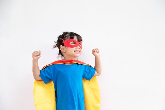 Menina criança joga super-herói. Criança em fundo branco. Conceito de poder feminino