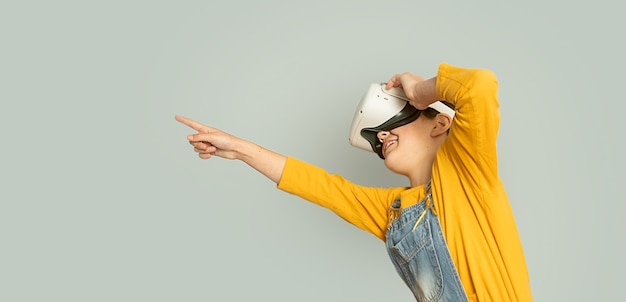 menina criança jogando realidade virtual isolada sobre fundo cinza