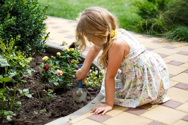 Menina criança no jardim doméstico