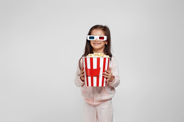 Menina criança usando óculos 3d redblue e comendo pipoca