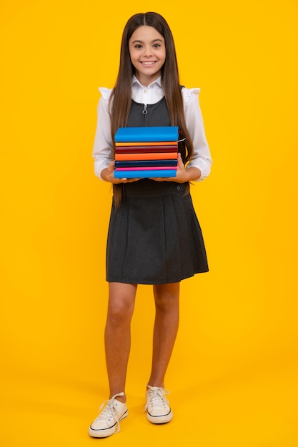 Foto menina da escola adolescente com fundo de estúdio isolado de livros