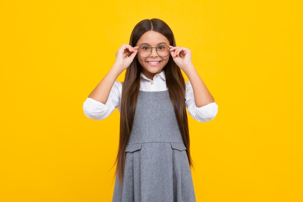 Menina da escola bonita usando óculos no fundo amarelo do estúdio menina inteligente inteligente em óculos Estudante nerd estudante gênio estudante Conceito de educação escolar