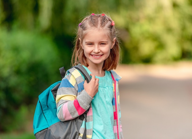 Menina da escola caminhando pelo parque depois da escola