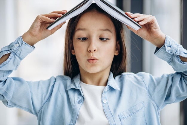 Menina da escola com livro em casa