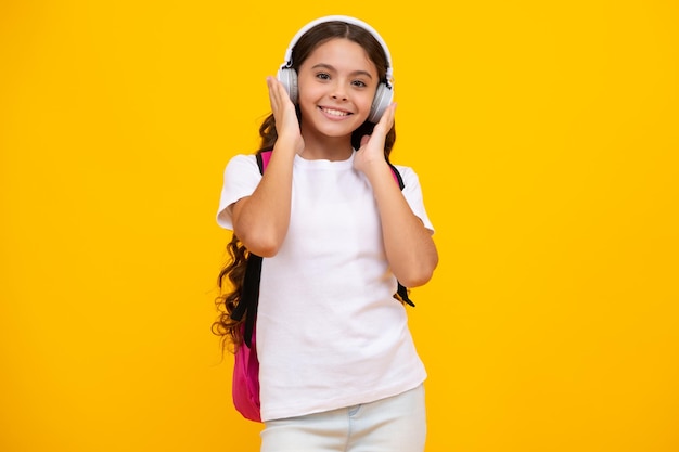 Menina da escola em fones de ouvido em fundo de estúdio isolado Conceito de escola e música