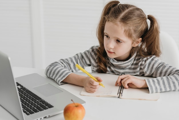 Foto menina da escola frequentando aulas online