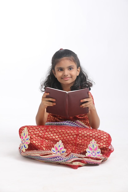 Menina da escola indiana estudando em fundo branco