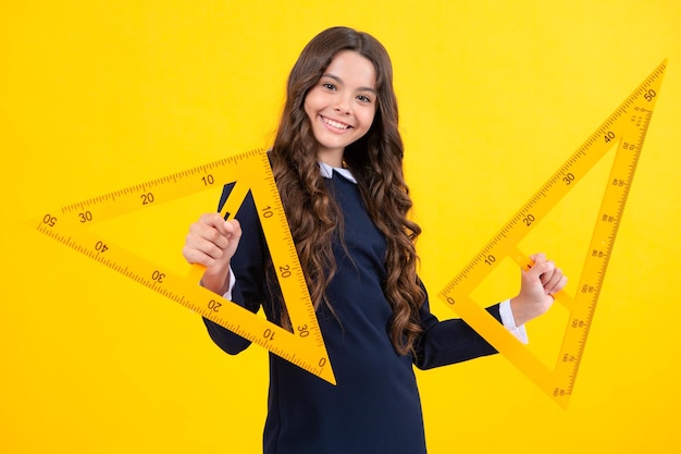 Menina da escola infantil adolescente segurando a medida para a aula de geometria medindo a altura equipamento de medição criança estudante estuda matemática dia do conhecimento