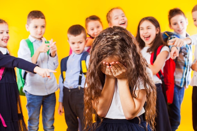 Menina da escola sendo intimidada por colegas de classe estudante chorando conceito de bullying escolar