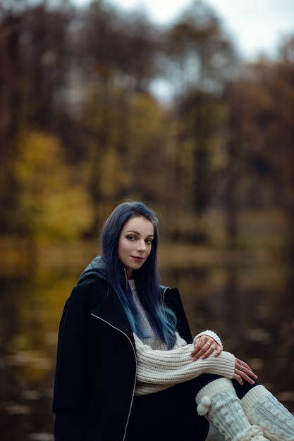 Menina da moda ao ar livre. Mulher outono se divertindo no parque e sorrindo.