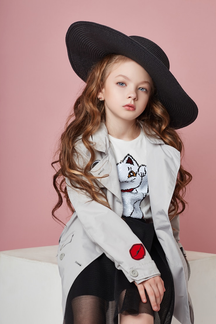 Foto menina da moda em roupas elegantes na parede colorida
