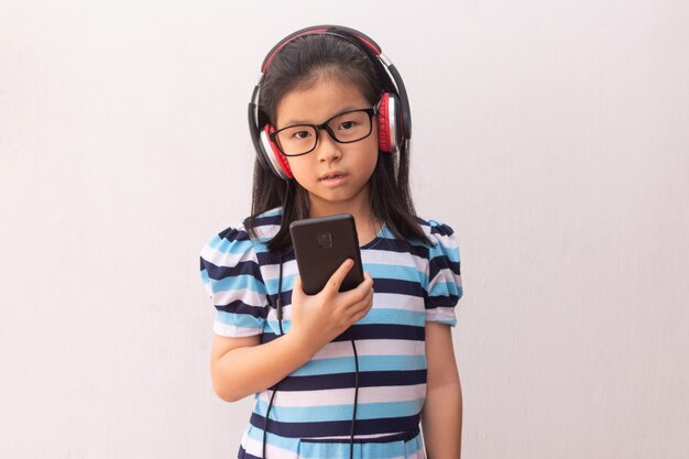 Menina da Ásia com fones de ouvido, ouvindo música