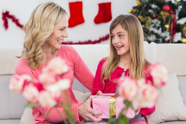 Menina dando a mãe um presente de Natal