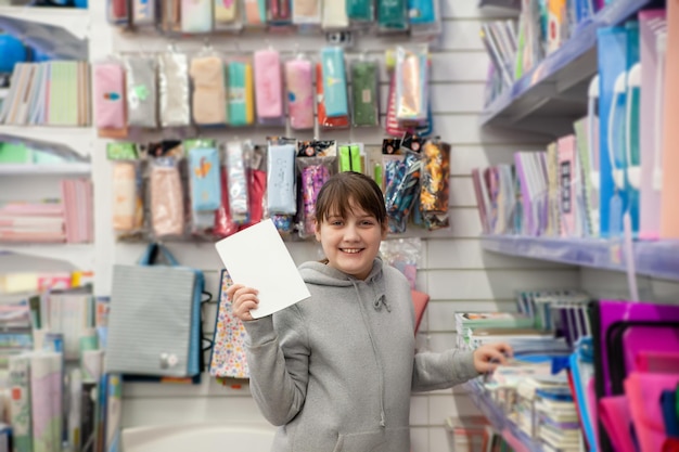 menina de 12 anos escolhendo cadernos na papelaria xDxA