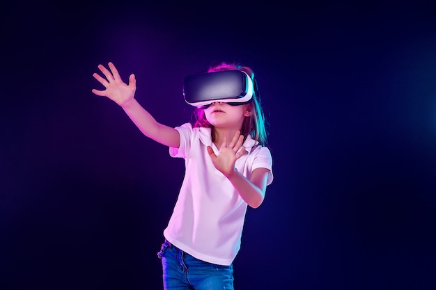 Menina de 7 anos experimentando jogo de fone de ouvido vr em colorido. criança usando um gadget de jogos para realidade virtual.