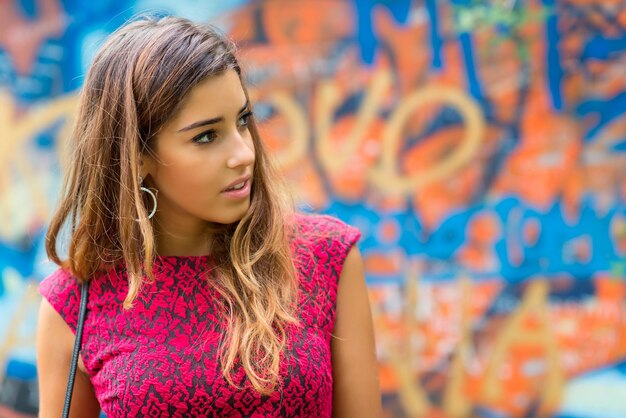 Menina de adolescentes linda em um retrato na frente de um mural colorido