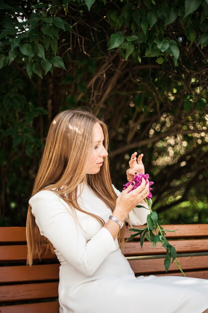 Menina de aparência européia com flores, peônias em suas mãos