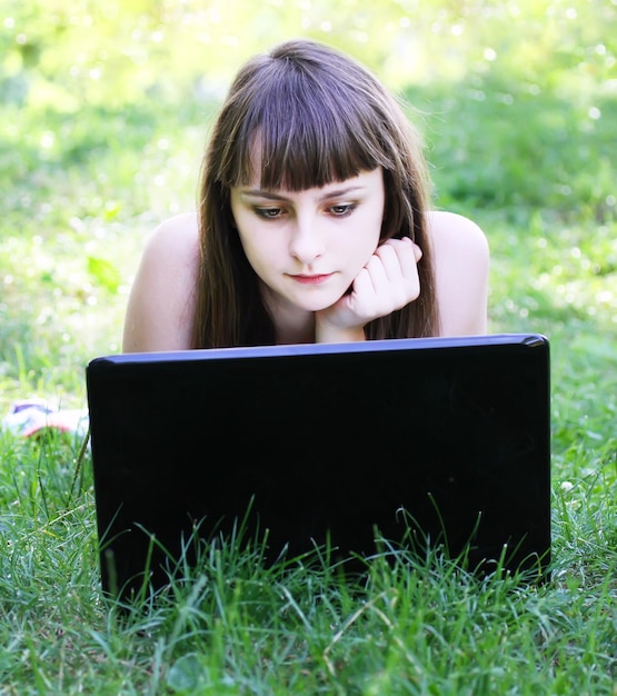 Menina de beleza com laptop ao ar livre