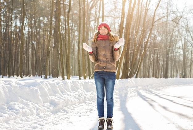 Menina de beleza soprando neve no parque de inverno gelado. Ao ar livre. Flocos De Neve Voadores.