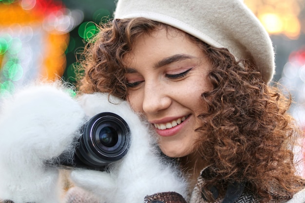 Foto menina de cabelo encaracolado bonito tirando fotos com a câmera