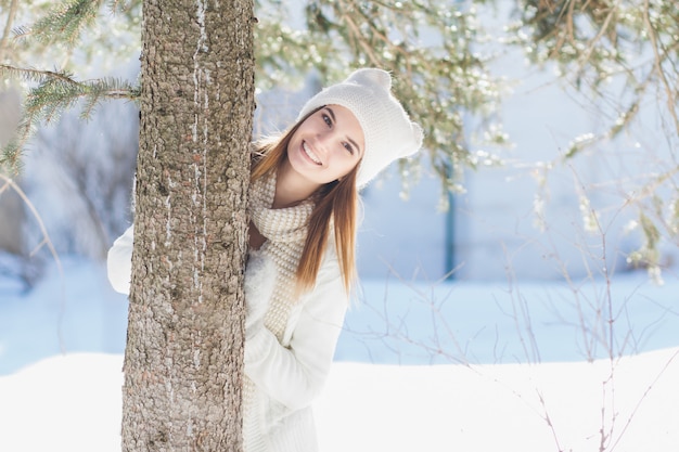 Menina de chapéu e luvas sorrindo no inverno