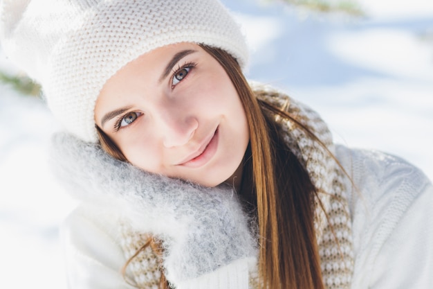 Menina de chapéu e luvas sorrindo no inverno