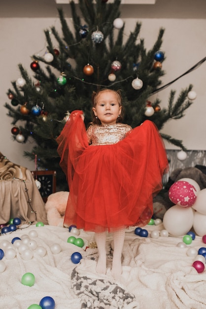 Menina de crianças felizes comemorando ano novo e Natal em uma árvore de Natal decorada e guirlandas