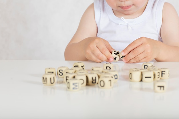 Menina de dois anos compõe palavras de letras. Fechar-se