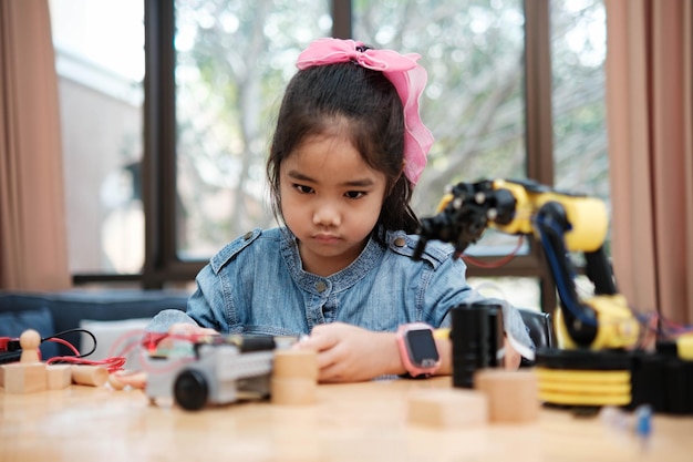 Menina de escola primária usa aplicativo para controlar carro em aula de STEM