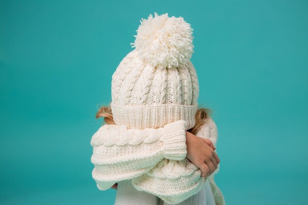 Menina de inverno branco de malha chapéu e blusa azul