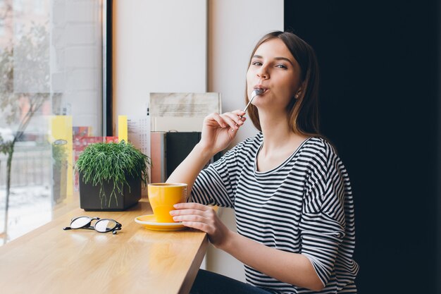 Menina de óculos, bebendo café