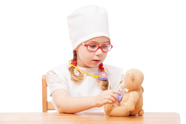 Menina de óculos brincando no médico