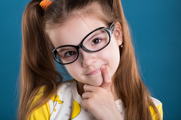 Menina de óculos e banana camiseta sobre fundo azul