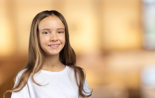 Menina de olhos azuis e cabelos loiros, sorrindo, olhando na câmera