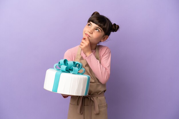 Menina de pastelaria segurando um grande bolo isolado