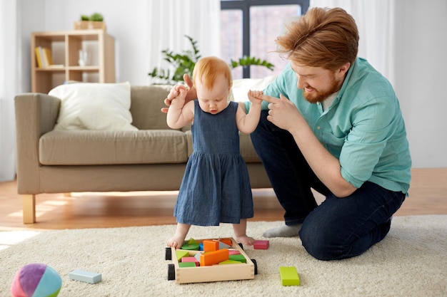 menina de pé com o pai ajuda em casa