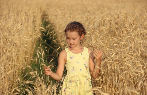 menina de pé em um campo de trigo