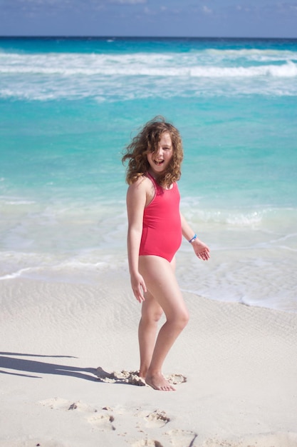 Foto menina de pé na praia durante o verão