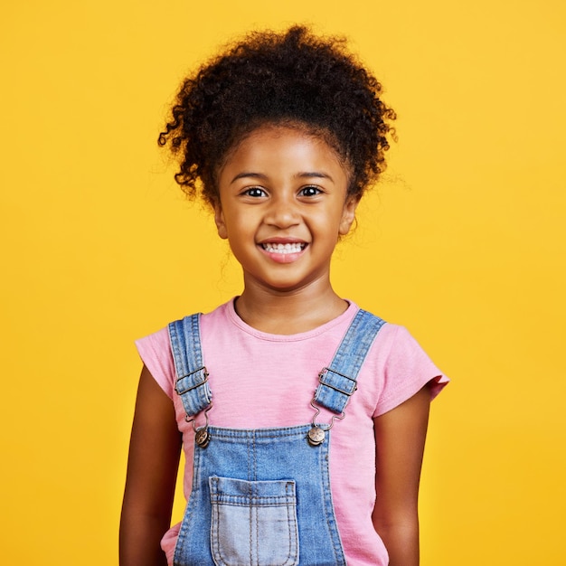 Foto menina de raça mista de retrato de estúdio olhando sozinha isolada contra um fundo amarelo criança hispânica bonita posando dentro criança feliz e fofa sorrindo e parecendo despreocupada em roupas casuais