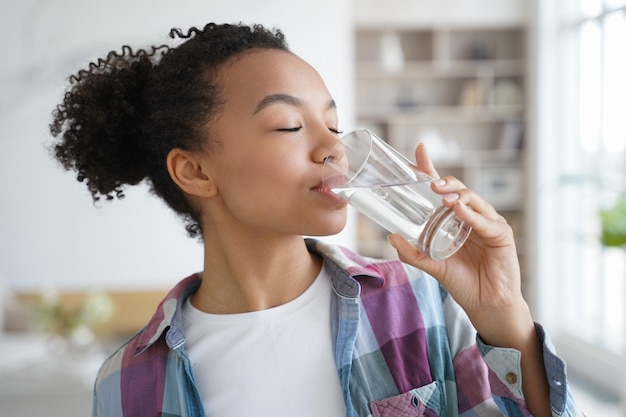 Menina de raça mista jovem bebendo água mineral limpa em casa Hábito de estilo de vida saudável beleza natural